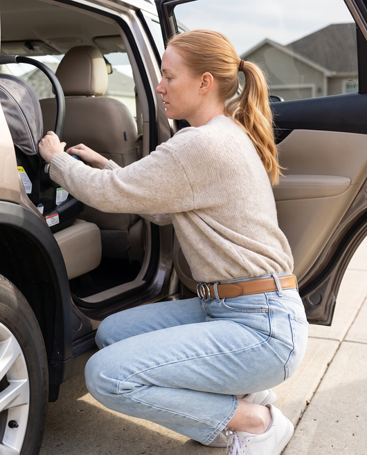 Tan belt with silver buckle keeping jeans up while crouching