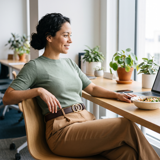 Woman seated at a desk wearing a mahogany belt with gold double-ring buckle